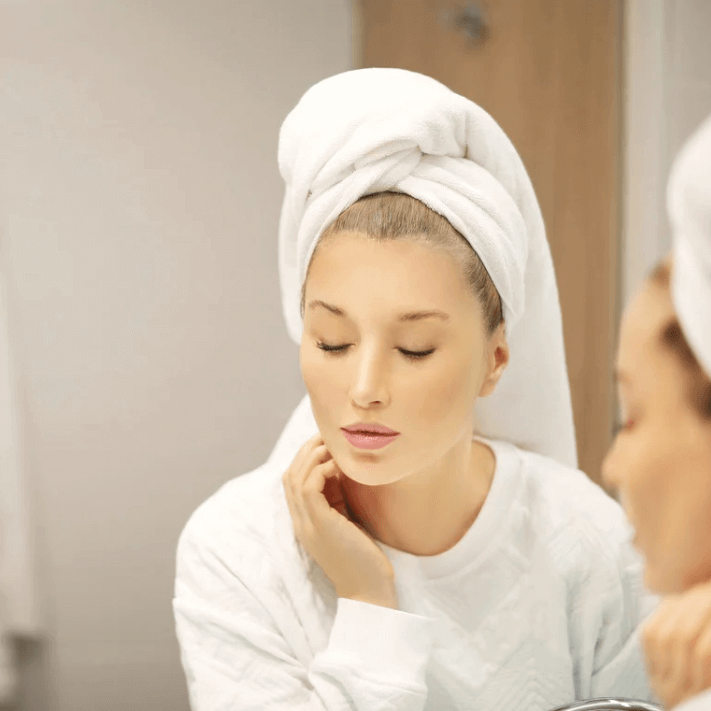 Model applying Luxevéria Skin Care Spray for a refreshing skincare routine.
