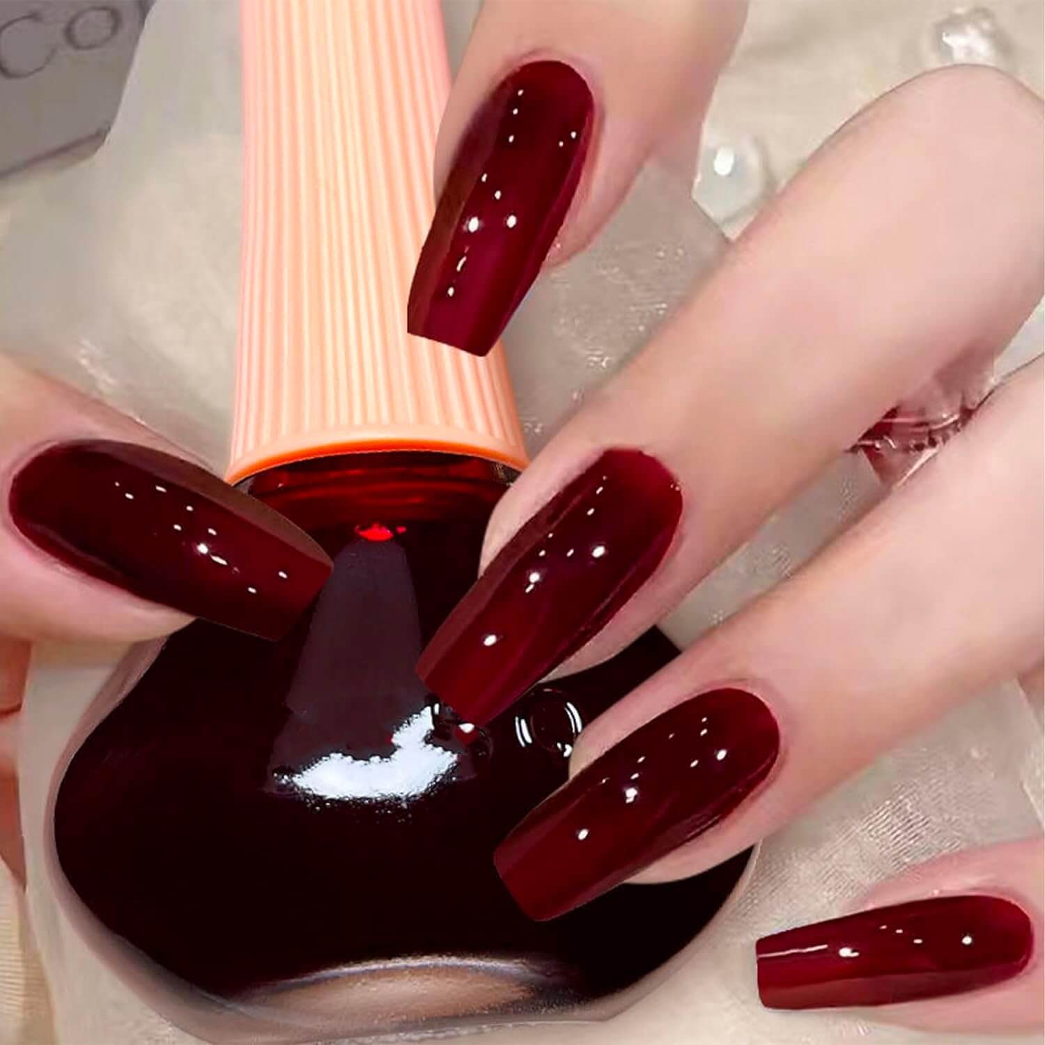 Revibe Zen Luminous Nail Polish applied on long nails in rich burgundy shade, showcasing high-impact mirror shine.